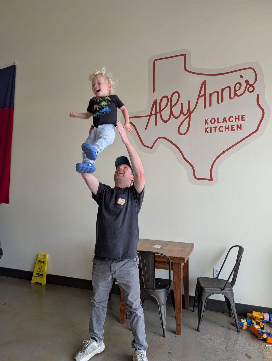 The owner playing with his son inside AllyAnne's Kolache Kitchen